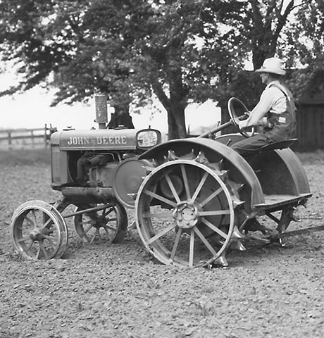 Tractorul universal istoric "GP" John Deere tractând o sapă rotativă nr. 7 John Deere pe câmp