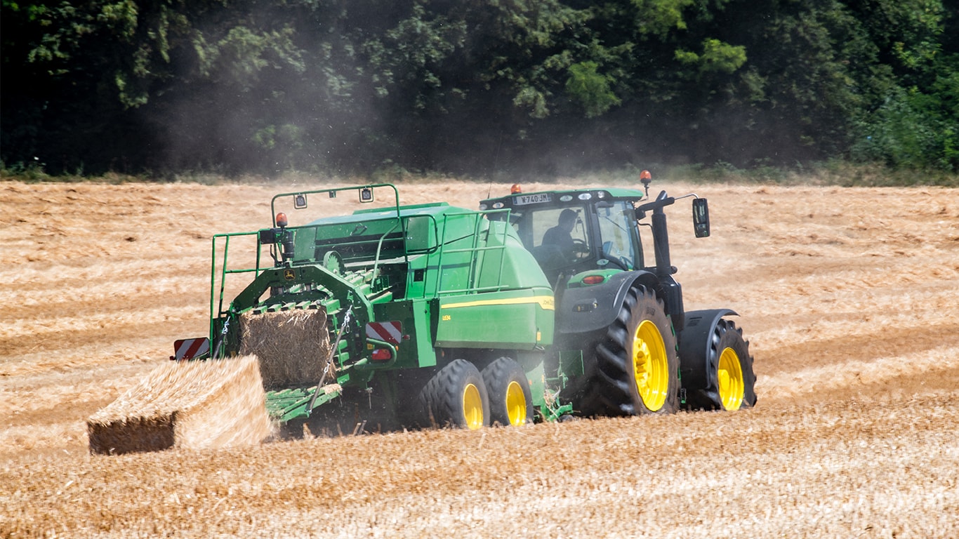 Presă de balotat mare John Deere L634 pentru baloturi pătrate cu tractor 6R pentru paie