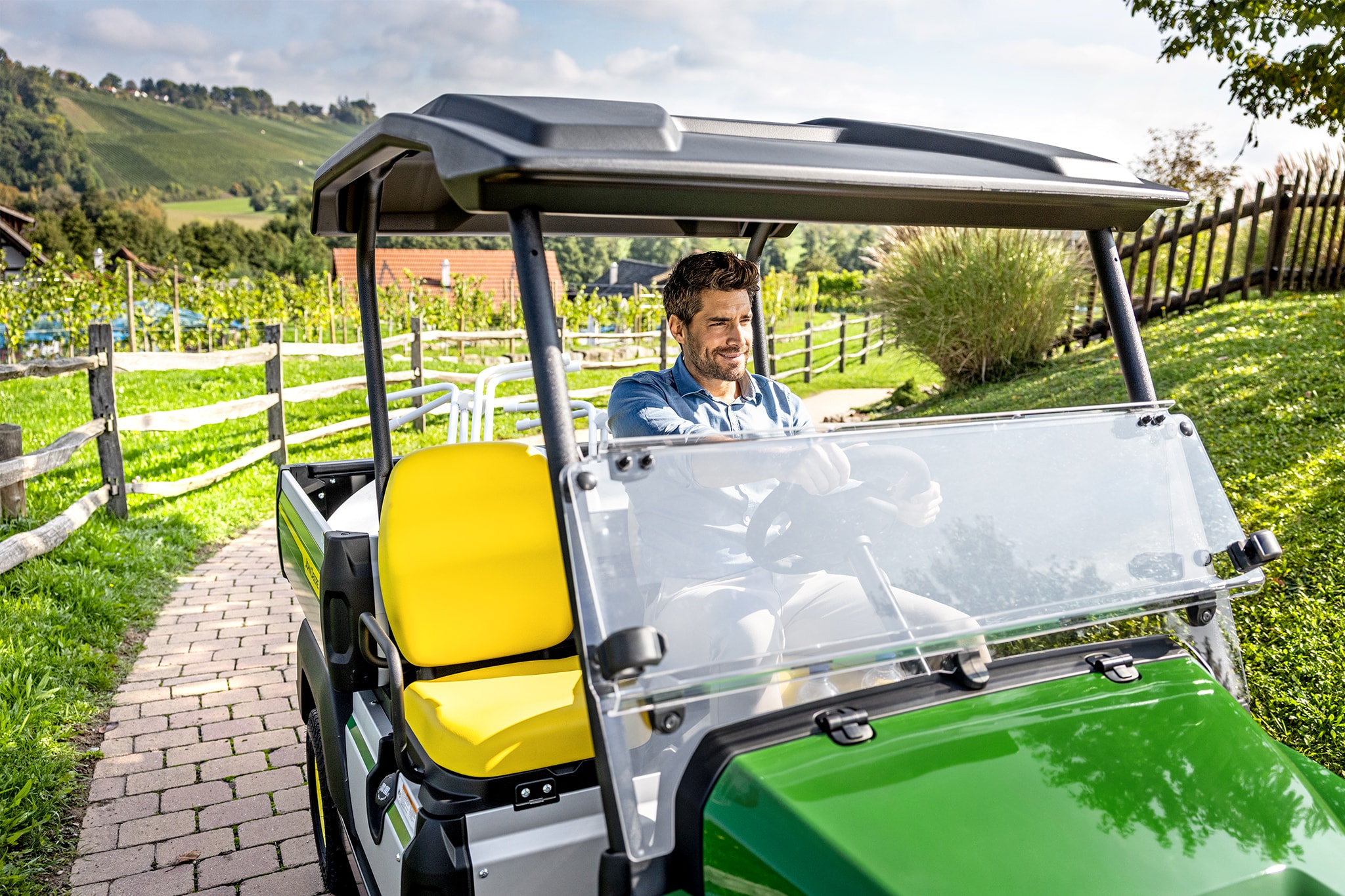 Prim-plan cu interiorul John Deere Gator GS, cu scaune şi volan galbene Prim-plan cu interiorul John Deere Gator GS, cu scaune şi volan galbene