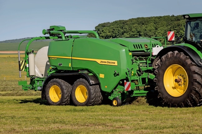 Presă de balotat cu sistem de înfoliere John Deere C442R care realizează baloţi de furaje de mare densitate